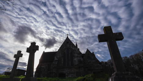 dramatic silhouette of a church and graveyard under a cloudy sky