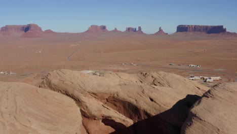 Aerial-shot-revealing-a-small-Navajo-village-below-Monument-Valley-Arizona