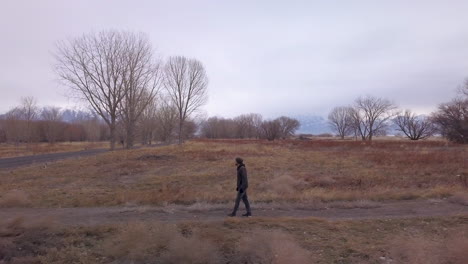 a man walks from a side trail to a paved path - sliding