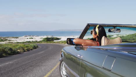 Mujer-Afroamericana-Con-Gafas-De-Sol-Sentada-En-El-Auto-Convertible-En-La-Carretera