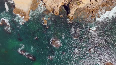 turquoise ocean and rocks on a beach in dana point, california, united states - aerial top down