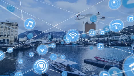 red de iconos digitales y un avión no tripulado que lleva una caja de entrega contra una vista aérea del puerto