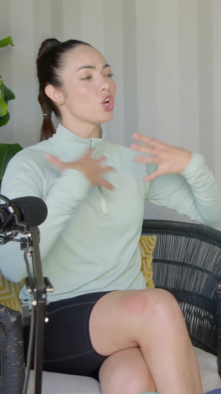 Vertical video: Replying to off cam cue, mint top guest gesturing into mic in studio with shaker