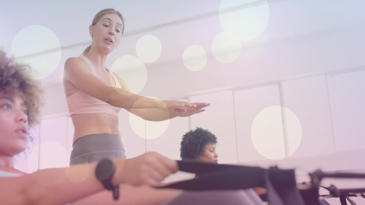 피트니스 강사가 운동 수업을 안내하고, 참가자들에 대한 보케 빛 애니메이션