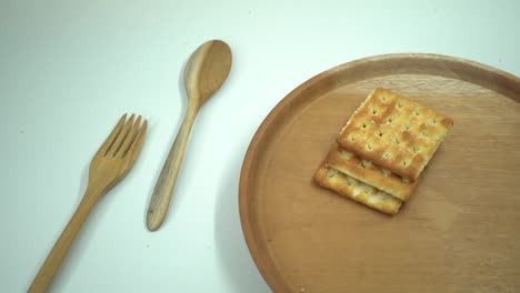 christmas cracker biscuit over the wooden plate, fork and spoon with white background.