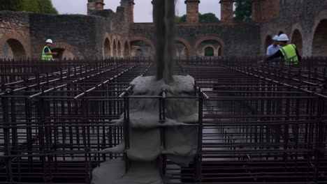 Concrete Pouring onto Rebar Framework at a Construction Site with Workers