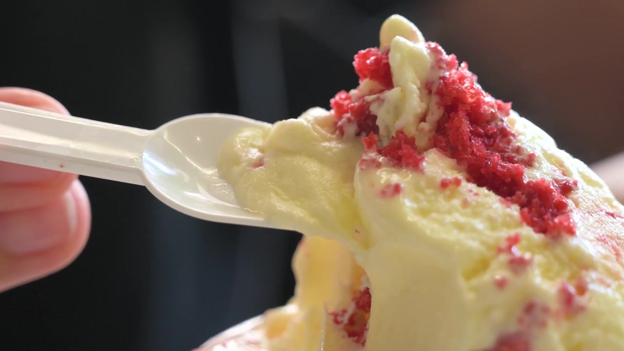 Toma macro de una persona tomando una cucharada de un delicioso postre gourmet congelado.