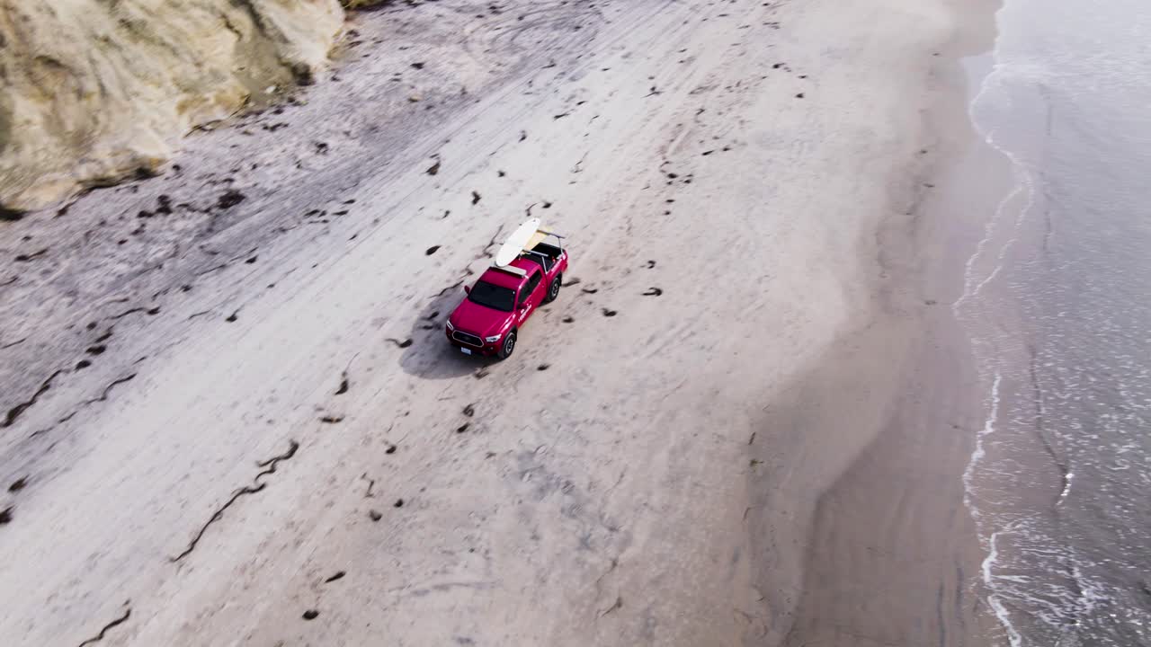 camión salvavidas rojo conduciendo por la playa en delmar, vista de drones, 4k