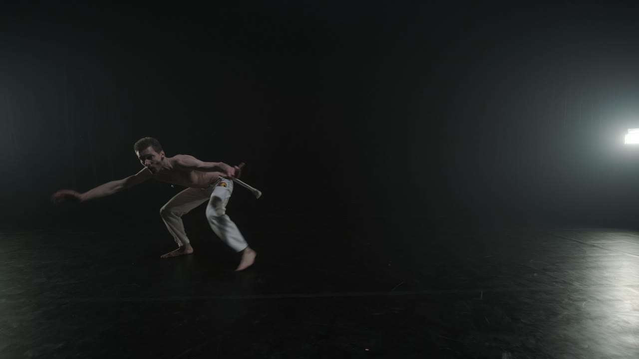 luchadores de capoeira realizando movimientos dinámicos en el escenario. artes marciales, danza y acrobacias en acción. atletas de pecho desnudo mostrando fuerza, flexibilidad y técnica bajo los reflectores