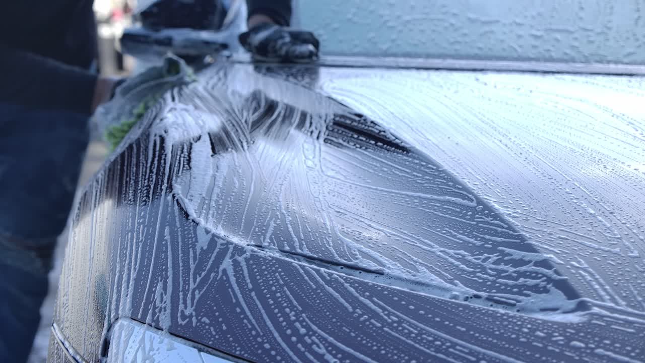 Autolavaggio self-service - Uomo che lava la sua auto con un panno