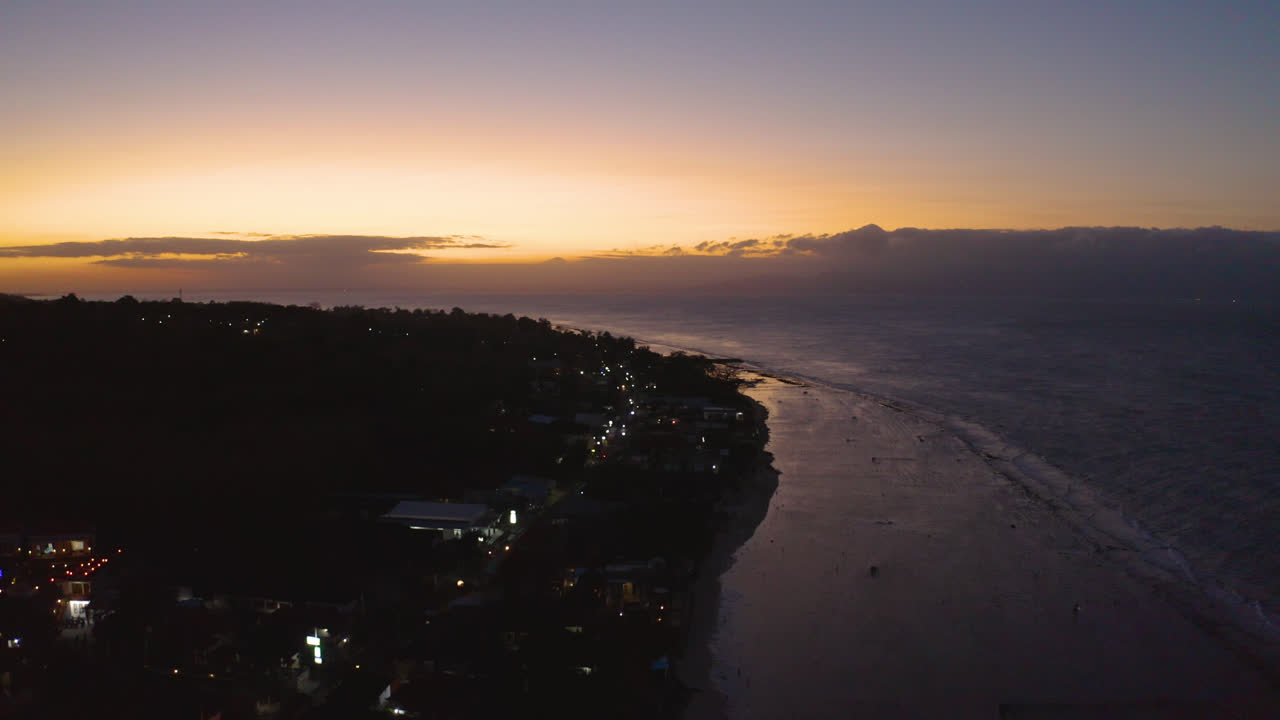 Amazing Golden Hour Sunset in Nusa Penida, Bali Indonesia rural island. Exotic tourist attraction with amazing colorful Sky and  Big Ocean waves crushing on white sand beach