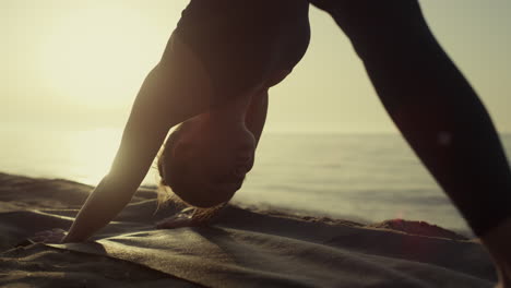 Yogi-Mädchen-übt-Asana-Im-Stehen-Mit-Nach-Unten-Gerichtetem-Gesicht-Und-Hund-Am-Sandstrand-Aus-Nächster-Nähe.