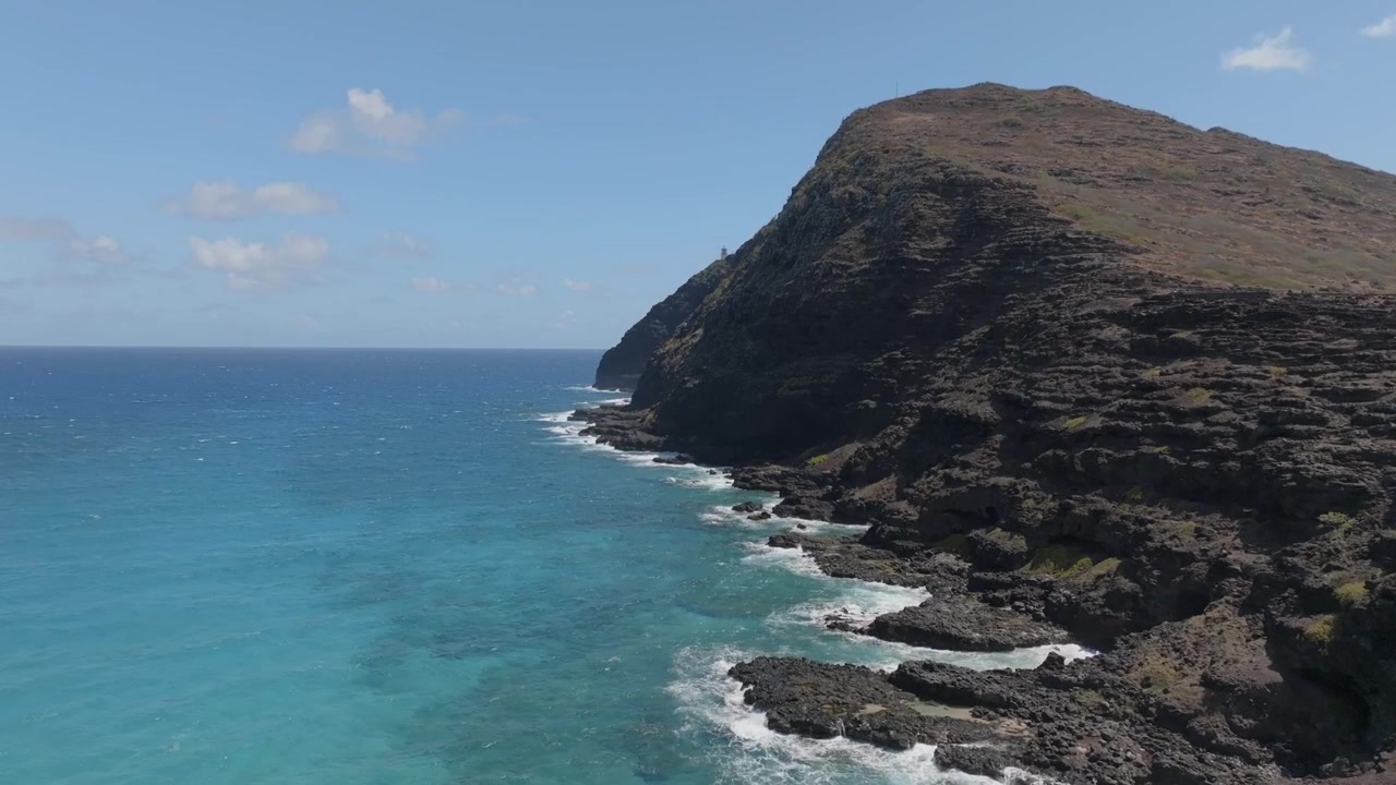 Volando lungo la costa con vista sul faro a Oahu, Hawaii