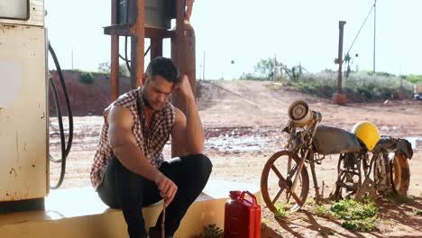 man sitting at petrol pump station 4k