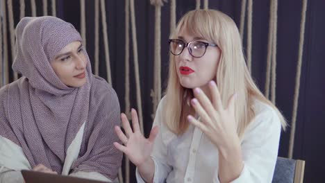 two women discussing in a cafe