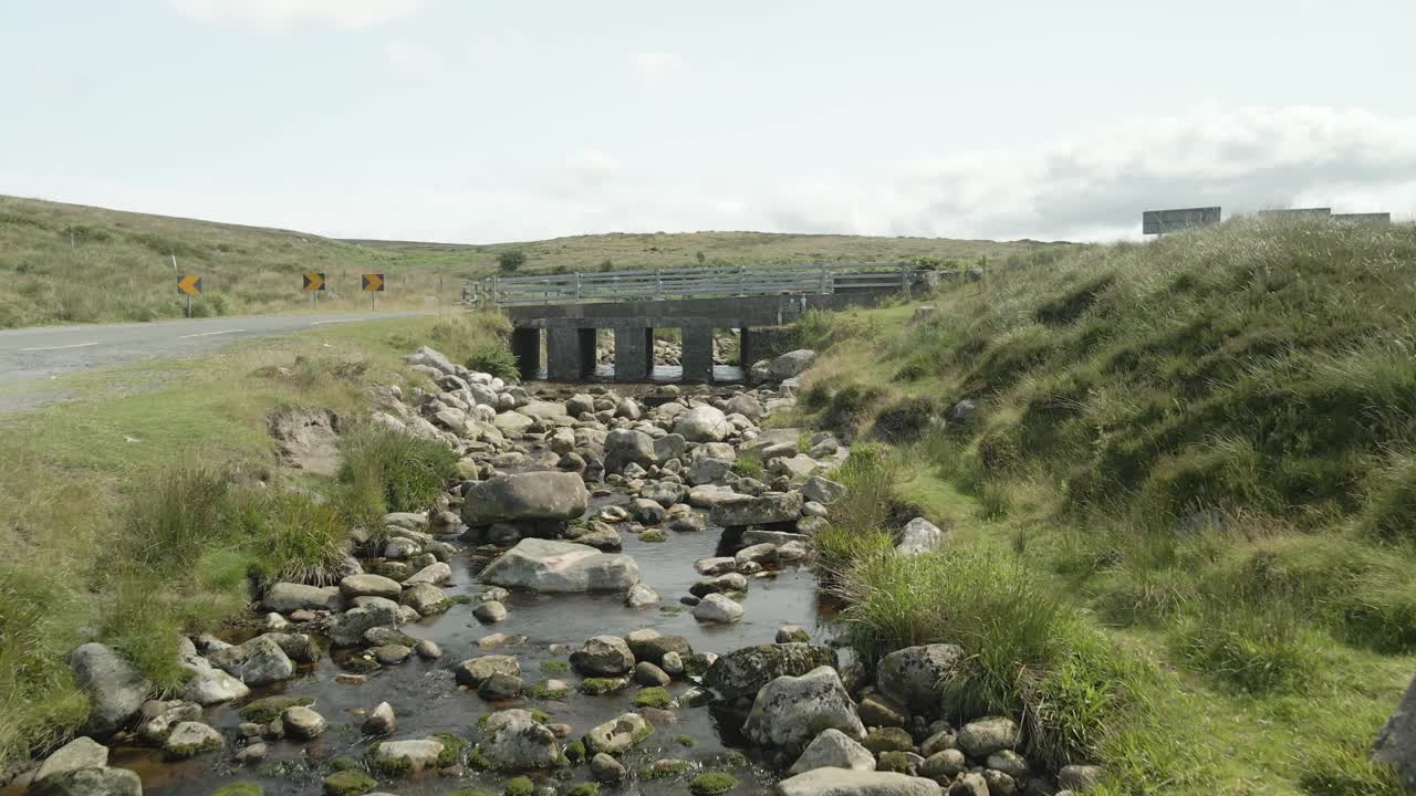 아일랜드의 울창한 위클로 산맥에 있는 바위줄기를 가로지르는 작은 다리.