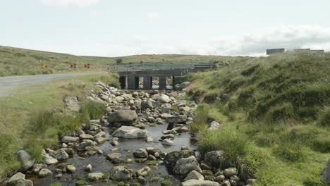 small bridge crossing a rocky stream in the lush wicklow mountains, ireland, on a bright day