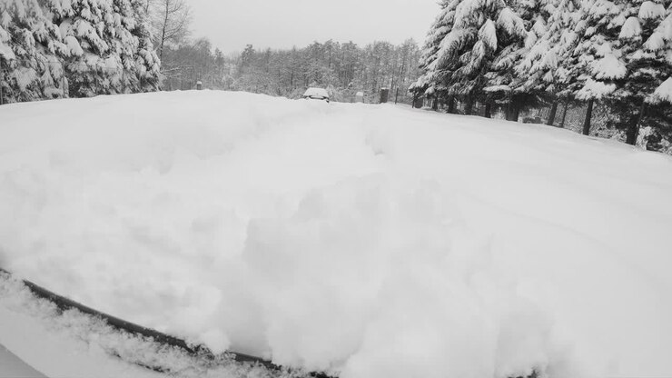 Rimozione della neve fresca dal vialetto del giardino e dal passo carraio dopo una bufera di neve invernale, POV