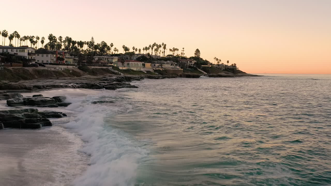 Dron volando bajo sobre el agua del océano en La Jolla, California.