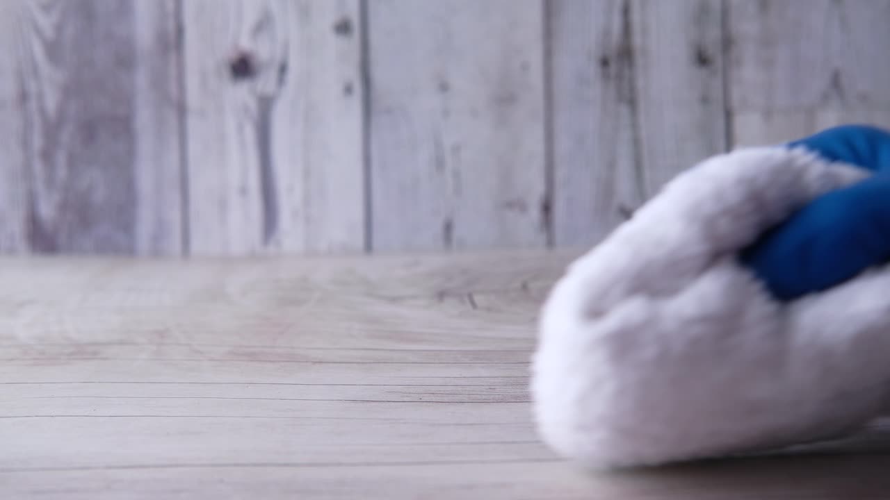 하 청소 수건을 들고 있는 파란 장갑의 손