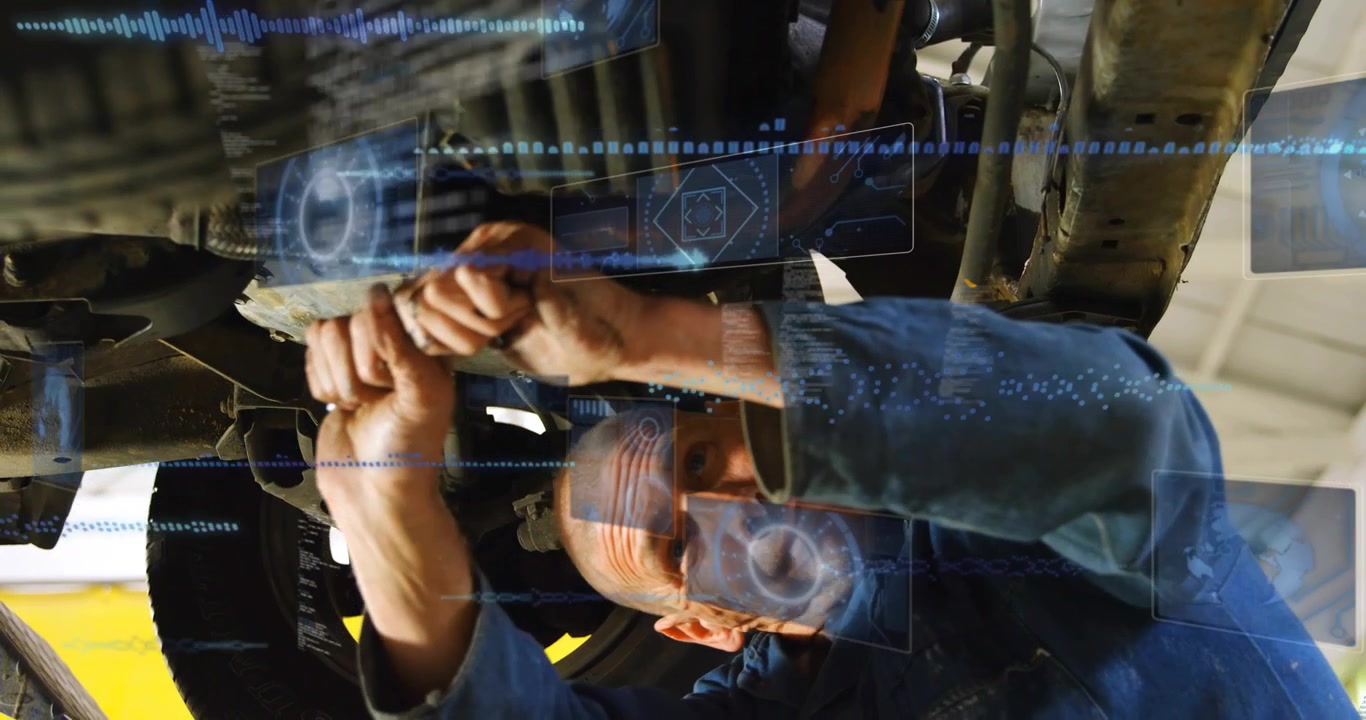 Male mechanic grasping wrench under lifted car, turning bolt while blue HUD overlay guiding repair