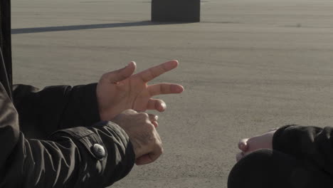 people talking outdoors near a large concrete structure