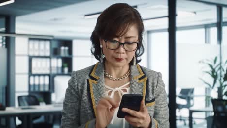 a professional woman engaged in a focused moment, browsing her smartphone in a modern office setting, embodying the essence of productivity and technology