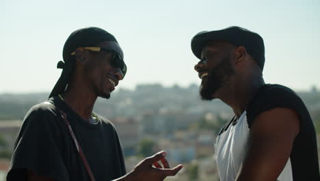 side view of cute afro-american gay couple talking during rooftop date