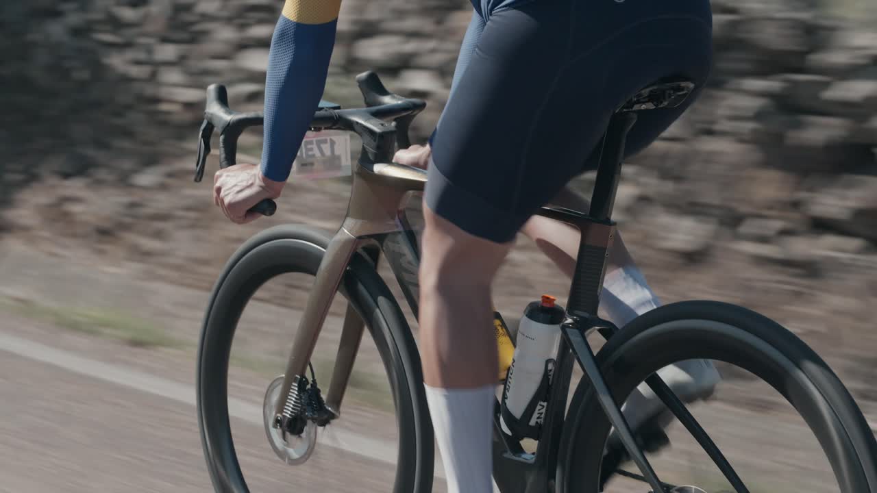 Plan de suivi dynamique d'un cycliste roulant à grande vitesse lors d'une course cycliste sur route, gros plan.