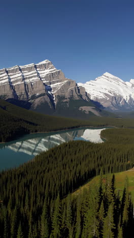 scenic mountain lake and forest landscape with snow-capped peaks