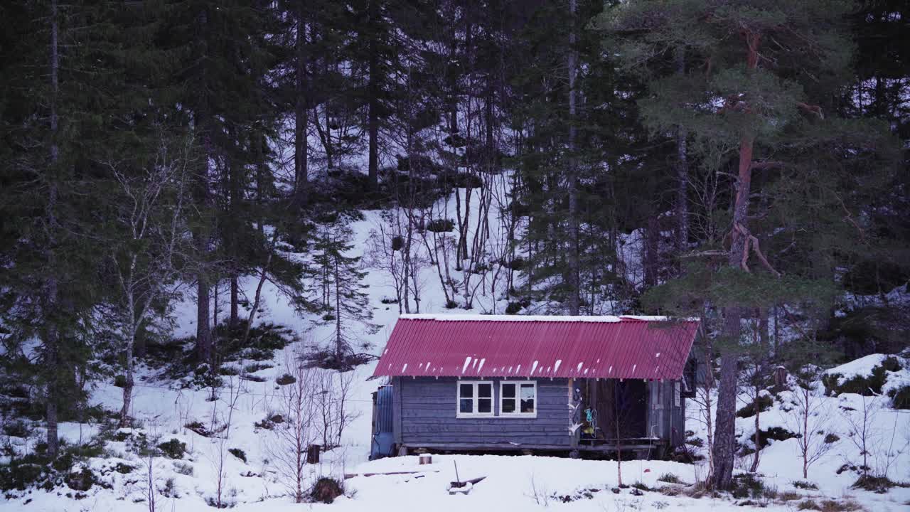 cabaña de madera rústica en la base de una montaña forestal durante el invierno
