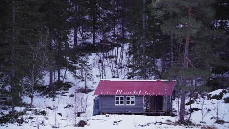 rustic wooden cabin on the base of a forest mountain during winter