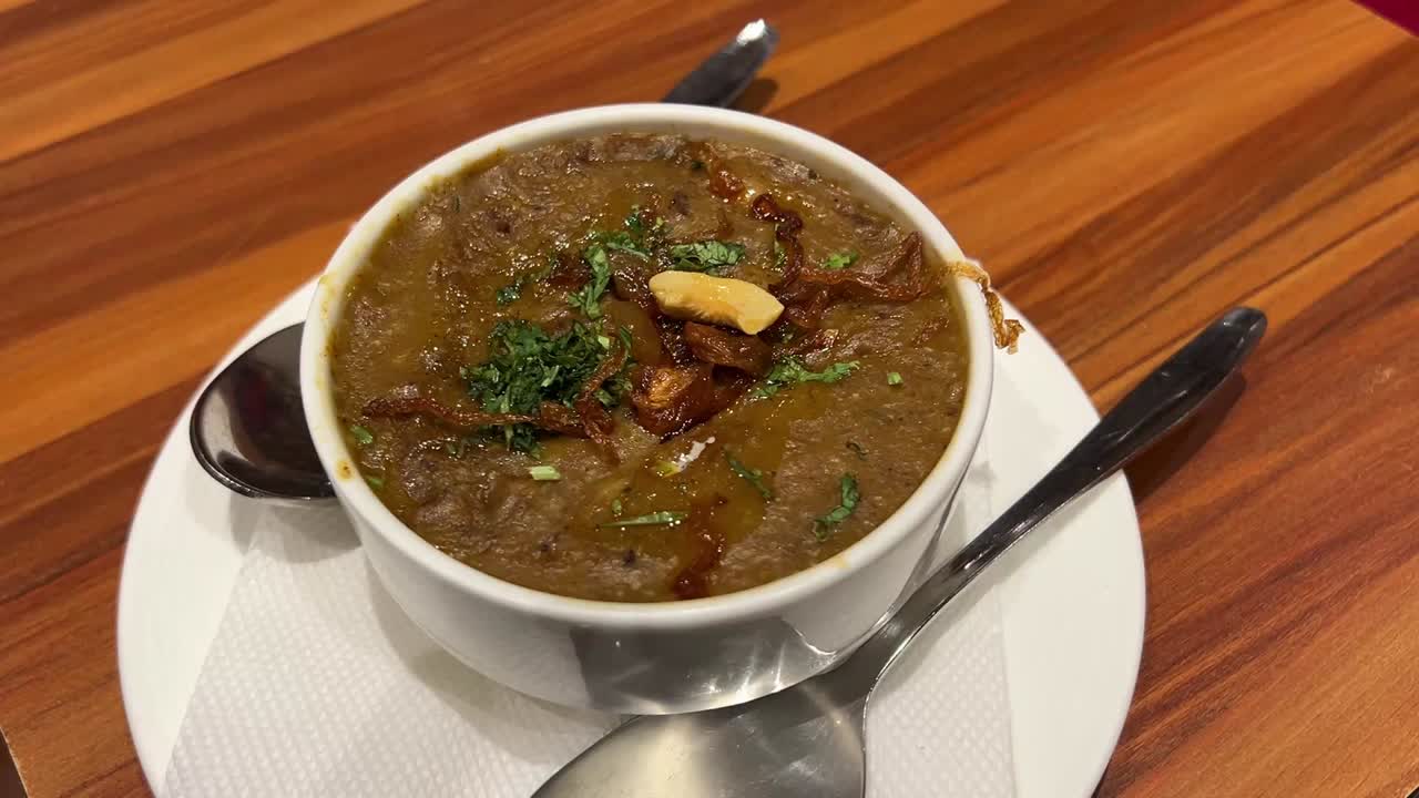 Hyderabadi Haleem served in a saucer with fried onions and coriander garnishing.