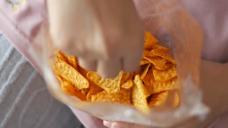 women holding a open potato chips packet ,