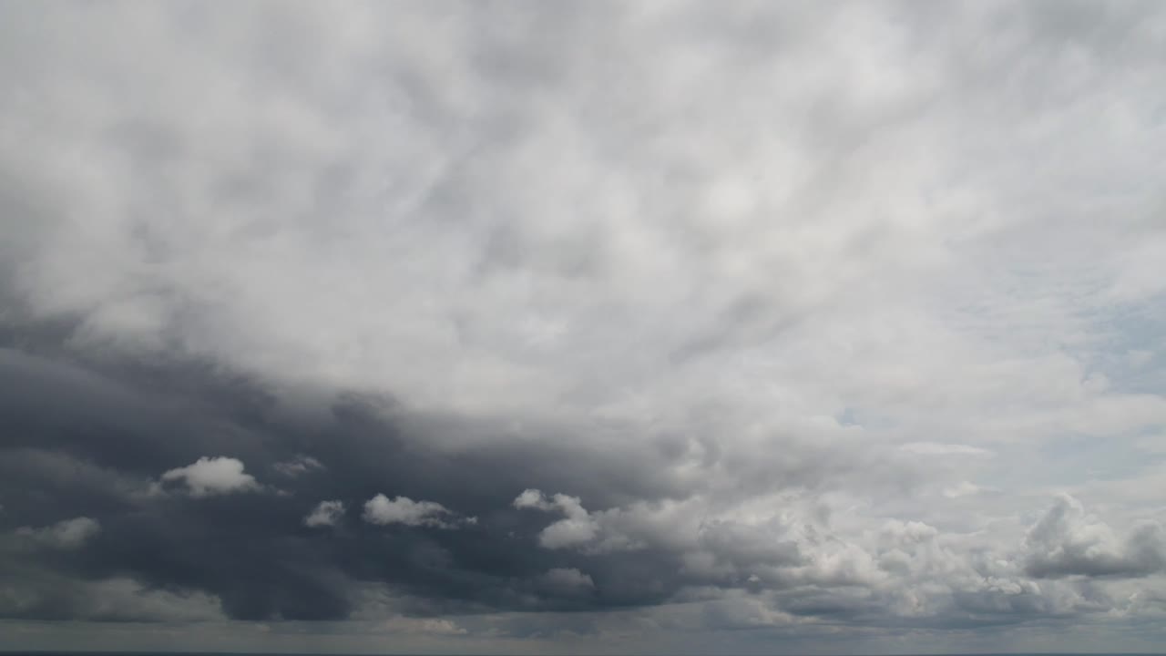 어두운 폭풍우 구름이 파란 하늘을 가로질러 움직입니다.