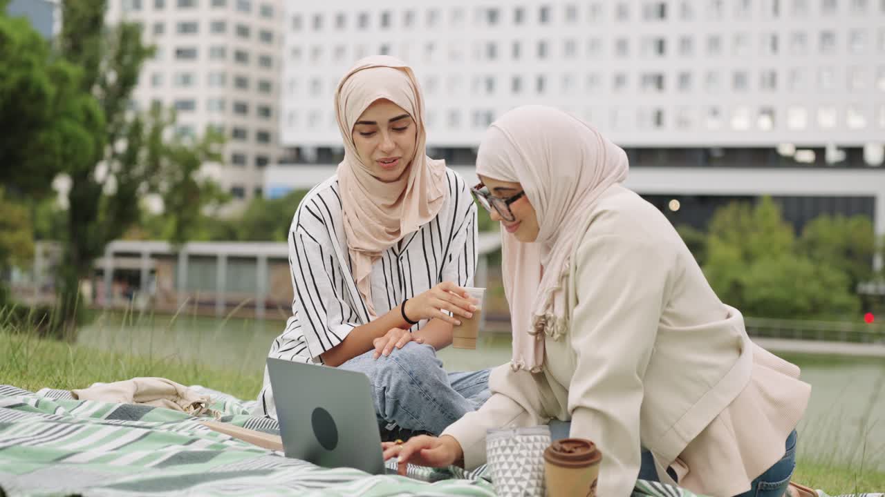 Two women in hijab having a picnic in the park
