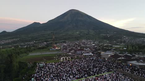 aerial view, thousands of worshipers praying eid al-adha or eid al-fitr in garung village, wonosobo. praying with the most beautiful view of mount sumbing and sindoro.