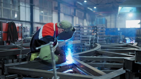 welder working on metal frame in a factory