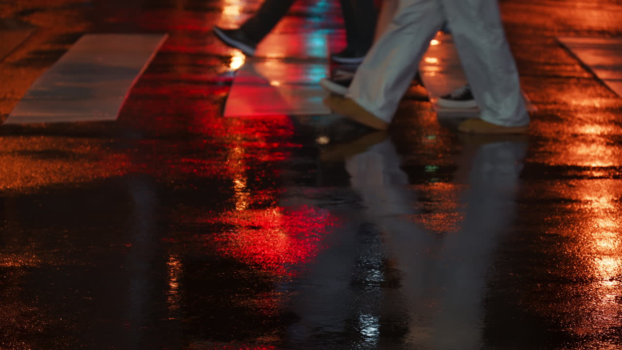 Pedestrians crossing the street on a rainy evening with city lights. Tokyo, Japan