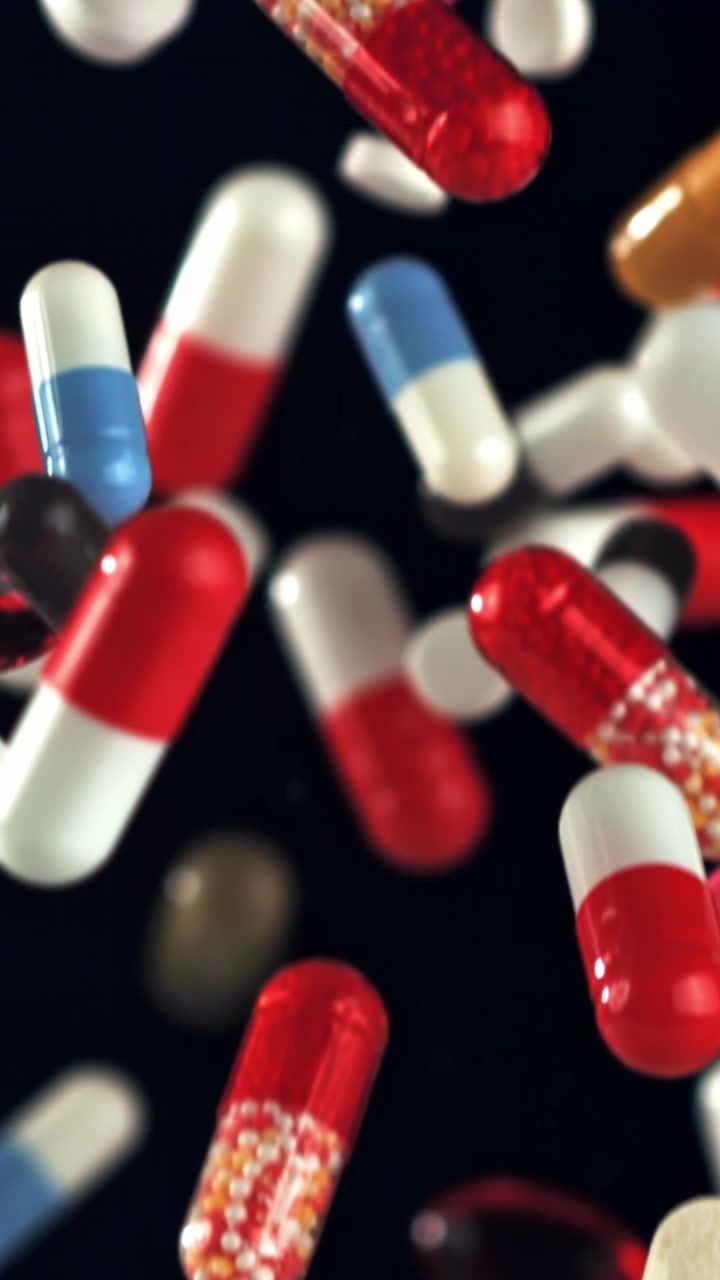 Various Colorful Pills and Capsules Floating in Slow Motion