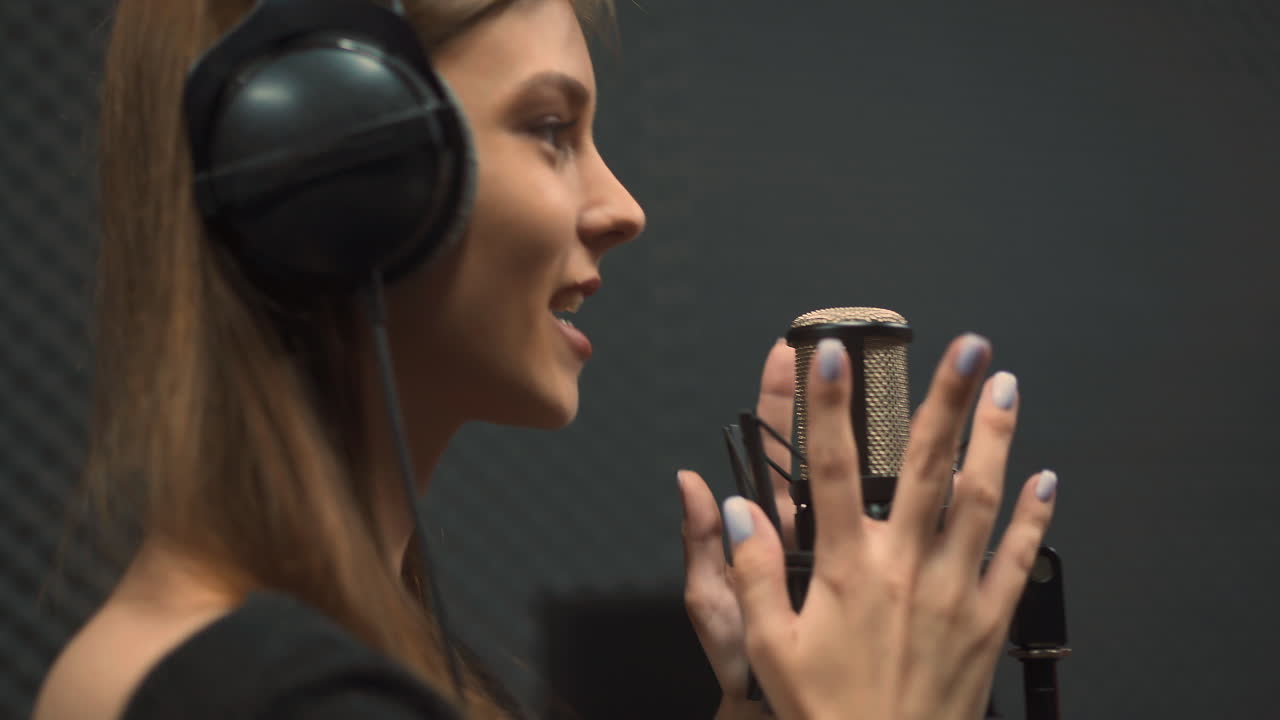 헤드폰을 쓴 기쁜 여성 보컬이 긍정적인 노래를 부릅니다.