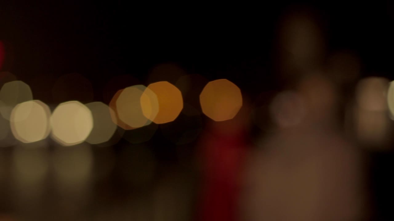 luces nocturnas desfocalizadas de la ciudad cerca de la torre eiffel en parís. color borroso bokeh de personas estáticas. panorámica de izquierda a derecha 4k.