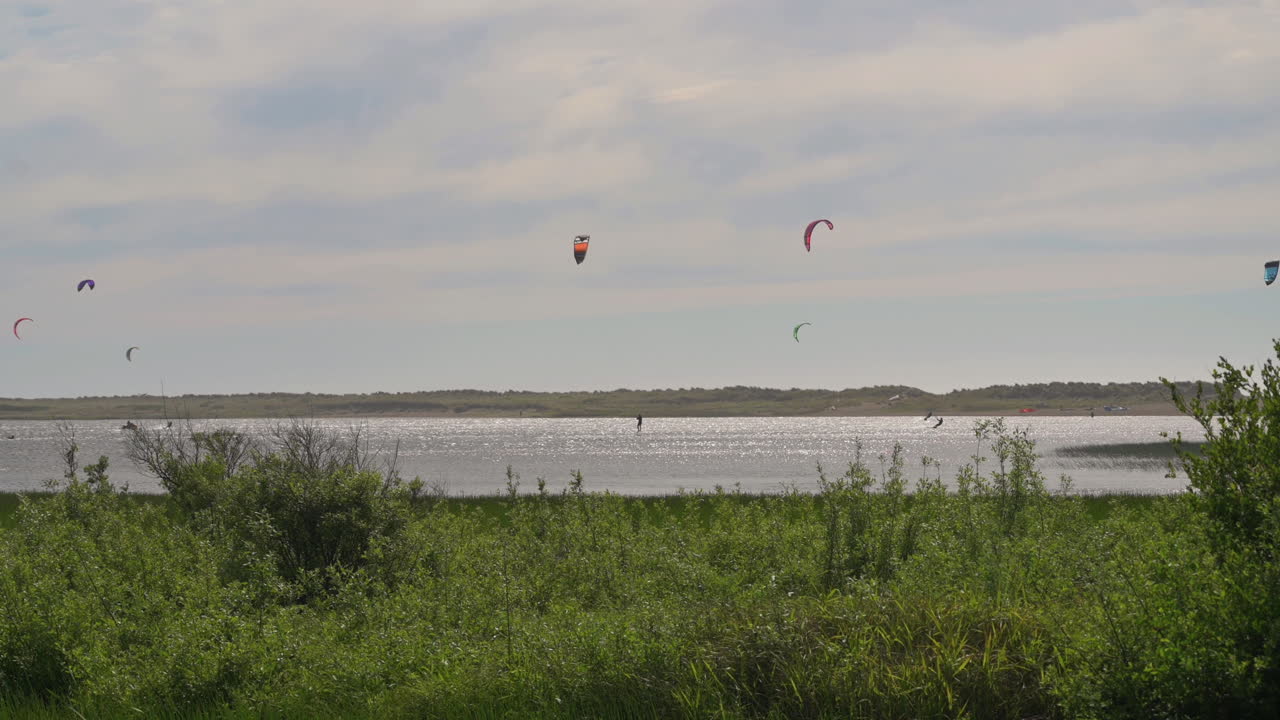 kitesurfistas navegando con el viento en el lago floras en oregon - plano general, cámara lenta