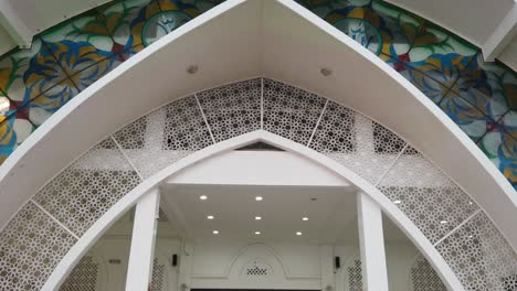 Slow moving ped down shot of architectural arch entrance mosque building of melaka in malaysia during day time