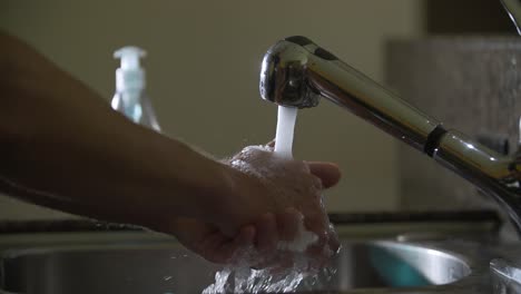 prevention coronavirus man washes his hands with running water and blue soap in sink