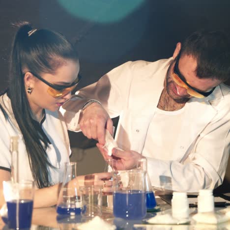 experiments in the laboratory of chemistry. chemists examine the flask with liquid. concept of science