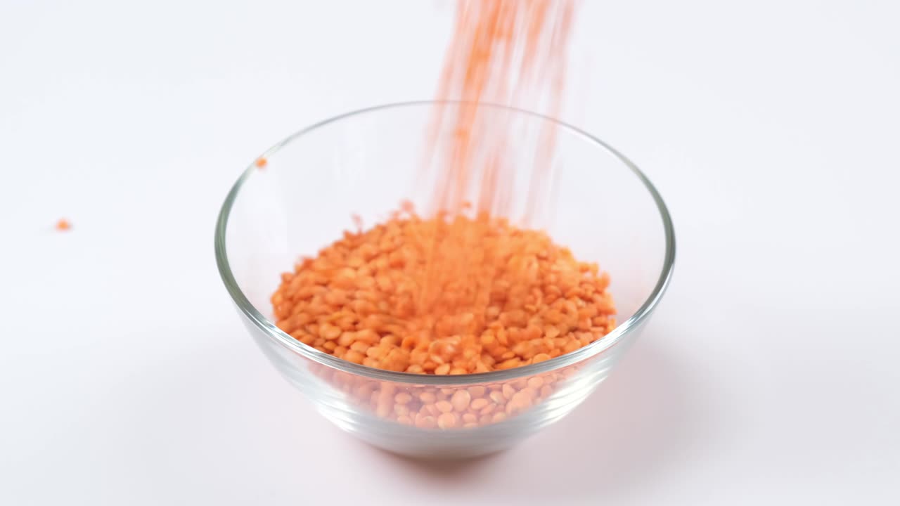 Red lentils in a glass bowl on white background. Healthy organic food diet concept. Fresh natural food ingredient