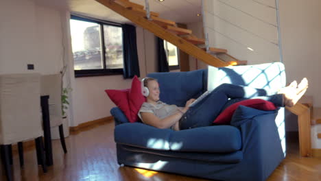 Woman-in-headphones-with-laptop-on-the-sofa