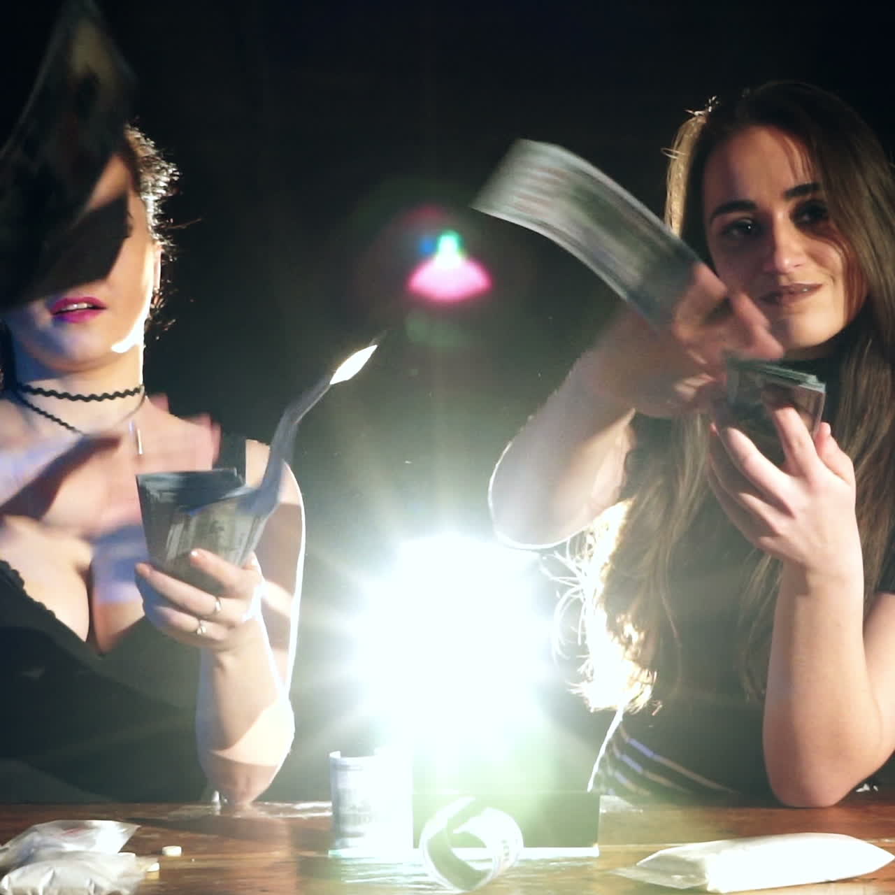 Two young female laughing and throwing american dollars in the air. Slow motion. Criminal Business