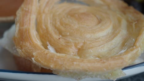 hand holding a puff pastry sandwich with egg